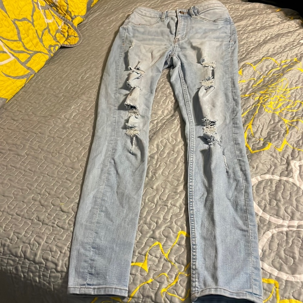 Blue ripped jeans with light pink stain on leg